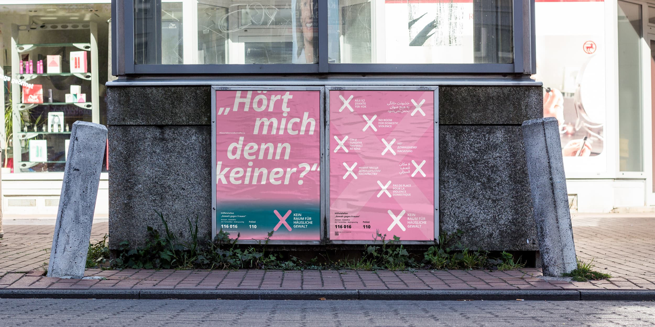 Plakat der Kampagne „Kein Raum für häusliche Gewalt“ mit dem Zitat „Seine Liebe tut weh“ und Hinweisen auf Hilfsangebote, platziert auf einer Werbefläche im öffentlichen Raum.
